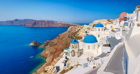 Santorini, Greece. Panoramic view of traditional houses in Santorini. Small narrow streets and rooftops of houses, churches and hotels. Oia village, Santorini Island, Greece. 