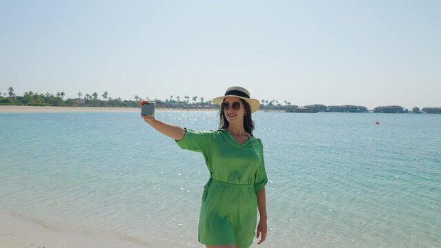 tourist woman in vacation happy holiday at luxury hotel tropical resort . Taking selfie at Banana Island at Doha Qatar

