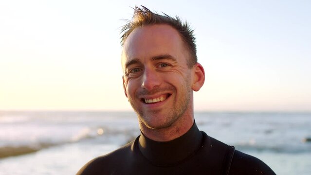 Portrait of a handsome male surfer in a wetsuit by the beach. Mature man waiting for the current, tide and waves to surf in the sea. Enjoying his recreational hobby time by the ocean