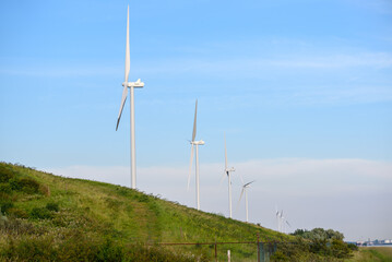 Row of tall wind turbines against clear sky in summer. Port of Rotterdam, Netherlands.