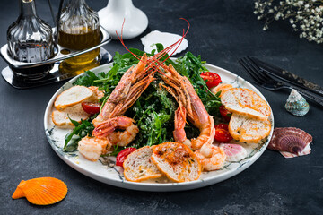 Salad with grilled giant langoustine shrimp, prawns and arugula. Black background