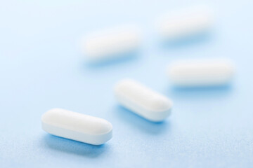 Obraz na płótnie Canvas White pills on blue background
