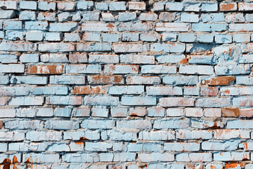 An old red brick wall painted with blue paint.