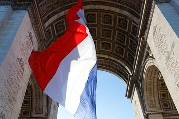 The French flag under the Triumphal arch. The tomb of the unknown soldier. Paris. France.