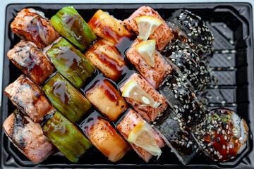 Sushi Set from the chef. Roll grilled gold, futomaki with fried tuna, avocado roll with salmon, grilled philadelphia with mango, cheese roll. Top view assorted sushi. Photo for website, menu