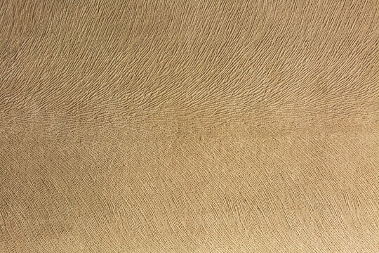 Artificial suede light brown background, textile imitation, velvet texture.