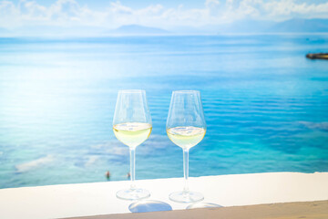 Two glasses of white wine with Corfu in background