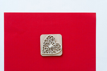 wooden heart on square and red and white paper