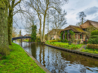 Beautiful thatched roof houses on Canal side in the fairy tale village of Giethoorn, Netherlands