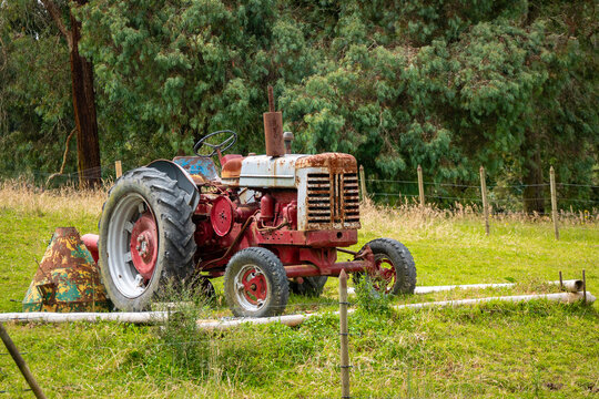 Santa Elena, Antioquia, Colombia - May 17 2022: Red Tractor in a Green Field