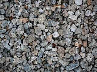 Small Stones in Shades of Blue-Gray and White in the Garden with a Bit of Trash on Top of Them