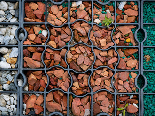 Pieces of Brick in Shades of Orange Under a Metal Square in the Yard