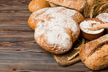 Homemade natural breads. Different kinds of fresh bread as background, perspective view with copy space