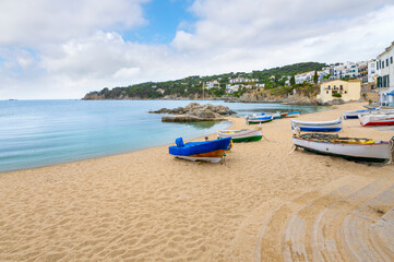 Fishing boats docked and moored on the sandy beach of the Spanish village of Calella de Palafrugell, Spain, on the Costa Brava coast.