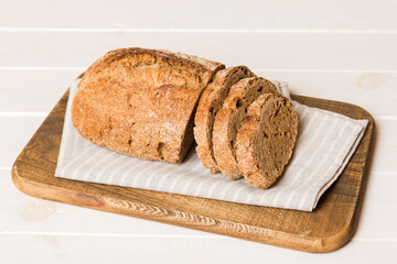 Assortment of freshly sliced baked bread with napkin on rustic table top view. Healthy unleavened bread. French bread slice