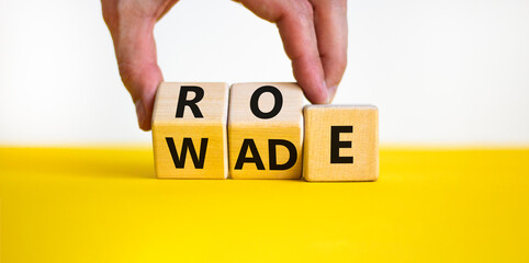 Abortion process Roe versus Wade symbol. Concept words Roe versus Wade on wooden blocks. Lawyer hand. Beautiful yellow table white background. Abortion process Roe versus Wade concept. Copy space.