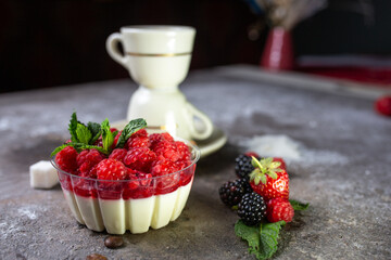 dessert panna cotta with fresh raspberries on a gray background