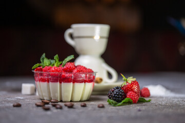 dessert panna cotta with fresh raspberries on a gray background