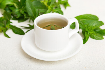 Cup of mint tea on table background. Green tea with fresh mint top view with copy space