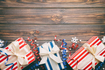 Holiday flat lay with gift boxes wrapped in colorful paper and tied decorated with confetti on...