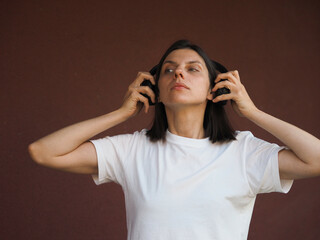 Young brunette woman wearing headphones. Young and stylish woman with dark short hair wearing a...