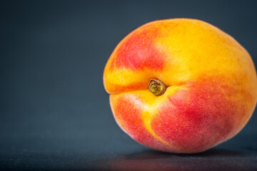 Ripe single apricot fruit over dark background closeup