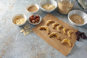 Baking healthy cookies from almond, oat flakes and dates with dark chocolate, ingredients on a rustic gray background, copy space, selected focus