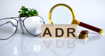 Text ADR on wooden block on the white background