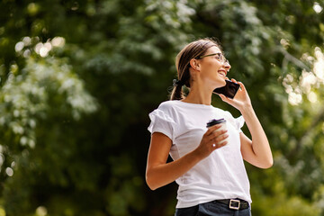 A girl in a park with a phone.