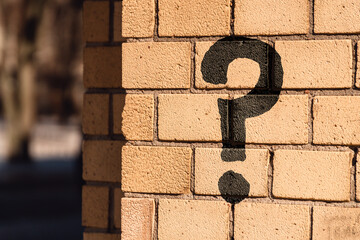 Question mark concept or FAQ. The sign is painted on a brick wall