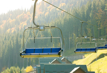 Bukovel, Ukraine, October 3, 2021. Empty ski elevator chairlifts in coniferous forest. Cableway to...