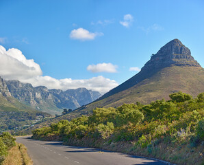 Landscape view of Lions Head mountain and the Twelve Apostles with blue sky with copy space in Cape Town, South Africa. Serene and tranquil asphalt road in the countryside in natural scenery.