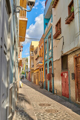 Fototapeta na wymiar Colorful historic buildings in vibrant city of Santa Cruz de La Palma with cobblestone alleyway on a sunny day. Bright residential houses in a popular village of a travel and tourism destination