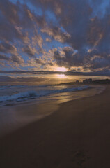 puesta de sol contra el sol en la playa con nubes en el horizonte