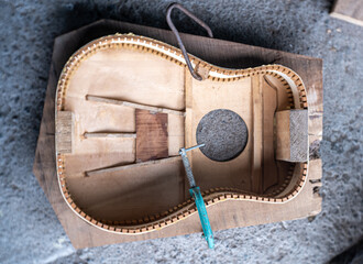 the process of making a handmade wooden guitar made of maple and spruss with quality not inferior...