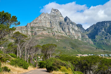 Below view of a mountain peak in South Africa against a cloudy blue sky with copy space. Scenic nature landscape of a remote hiking and travel destination to explore near Table Mountain in Cape Town