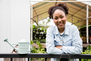 Charming of woman gardener in small floral center with happiness and bright smiling. Joyful woman...