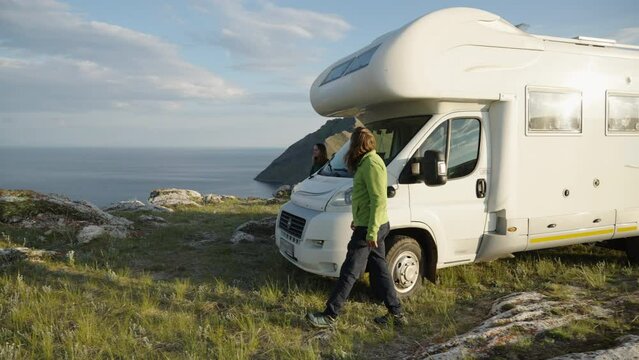 Motorhome RV camper van road trip, couple get out motorhome and looking at sea
