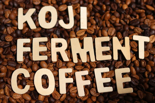 
Koji ferment coffee word on roasted coffee beans background. Concept of koji-fermented coffee, coffee fermentation and  fermentation of koji.  