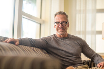 Mature man sitting on a sofa sock photo