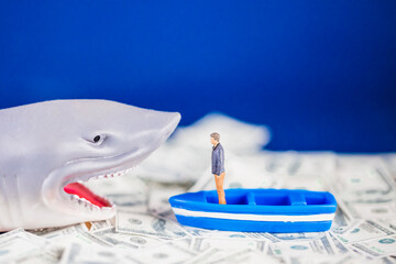 Miniature man on a small blue boat facing a loan shark on the dollar ocean. Loan shark concept