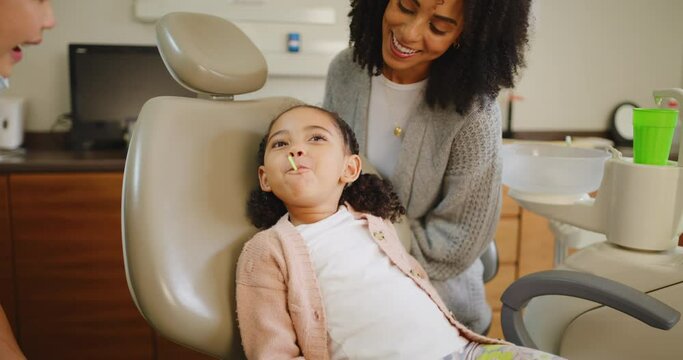 Little girl sucking a lollipop after a dentist checkup and orthodontist appointment. Cute female child eating a sweet reward after completed oral or dental exam to prevent tooth decay and gum disease