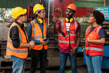 Foreman is taking orders in the factory. Factory worker and engineer as team. Engineer men wearing...