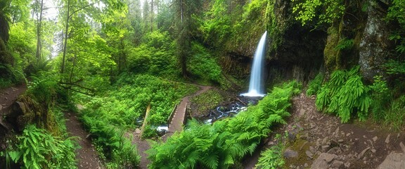 A waterfall with a bridge in deep forest cascades is located in the Columbia River Gorge in Oregon Beautifull waterfall background