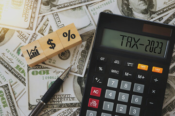 the word tax on the calculator  and icons on wooden blocks  Business and tax concept. Tax collection. New year tax concept.