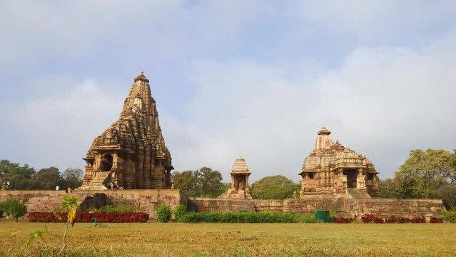 A stunning timelapse of Khajuraho Temple shows clouds drifting across the sky while the majestic structure stands firm, its intricate carvings glowing as light and shadow dance over timeless stone.