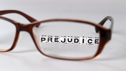 The concept of biased views judged by appearances. Business concept with white cube arranged in the word  ’PREJUDICE' and glasses.
 - obrazy, fototapety, plakaty