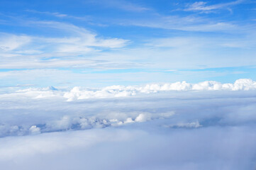 飛行機の窓から見える青空・雲の上景色の眺め