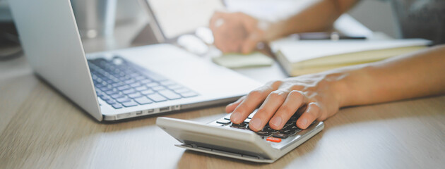 close up hands of accountant calculating tax refund using calculator