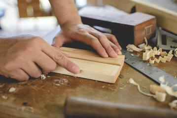 Hands of person doing diy project at home. Man measuring wood to doing cabinet craftworks as a hobby.